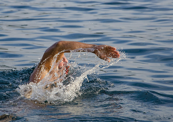 Mann schwimmt im See