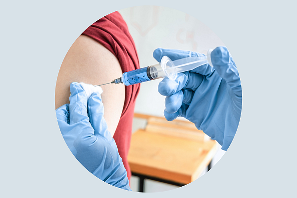 Person die in einen Arm impft.