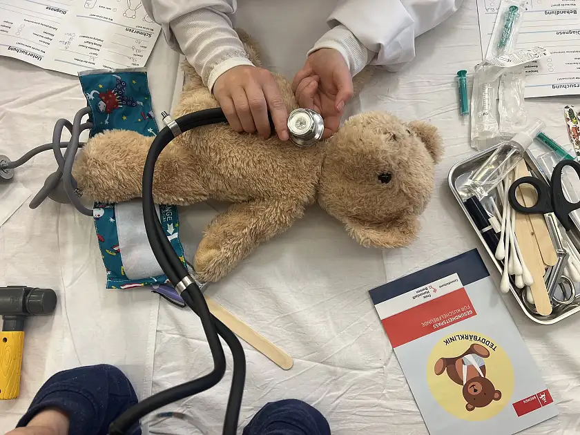 Foto auf dem ein Teddybär auf dem Untersuchungstisch liegt